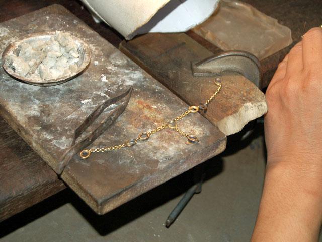 金のブレスレットを加工中