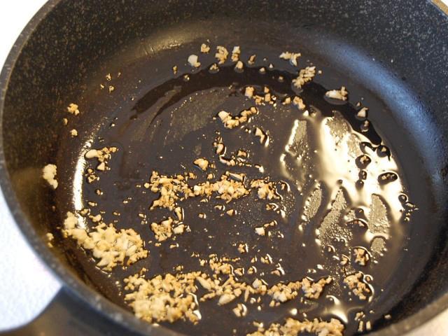9. フライパンに多めに油を熱し、ニンニクが薄っすらきつね色になるまで炒める。 
