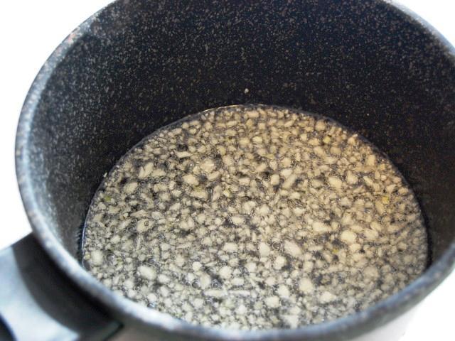 6. フライパンに多めの油（ニンニクが浮く程度）と、5.のニンニクを加えて、ニンニクが薄っすらきつね色になるまで炒め揚げにする。 
