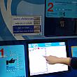 自動チケット販売機の画面をタッチし、言語を選択し、目的駅のボタンを押します。