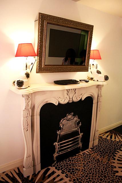 絵の額のように見えるものは、実は薄型TVです。両脇の犬型のランプもキュート。下の暖炉は張りぼてで、まるでお芝居のセットのよう。