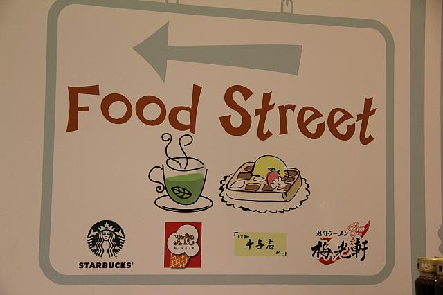 奥に続くお惣菜・フードコートの案内板