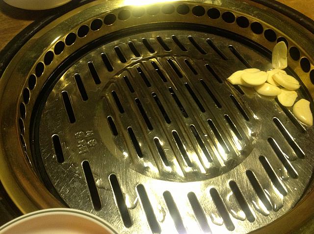 油を敷いたグリルにニンニクが入ります