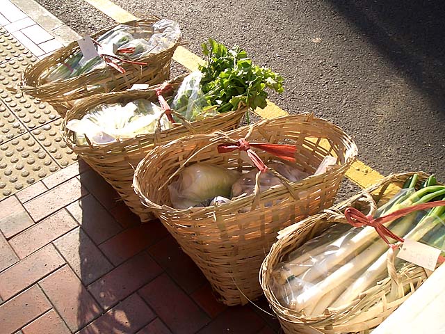 かごに入ったみずみずしい野菜も、なぜか陽のあたる車道側にずらりと並べられ…。