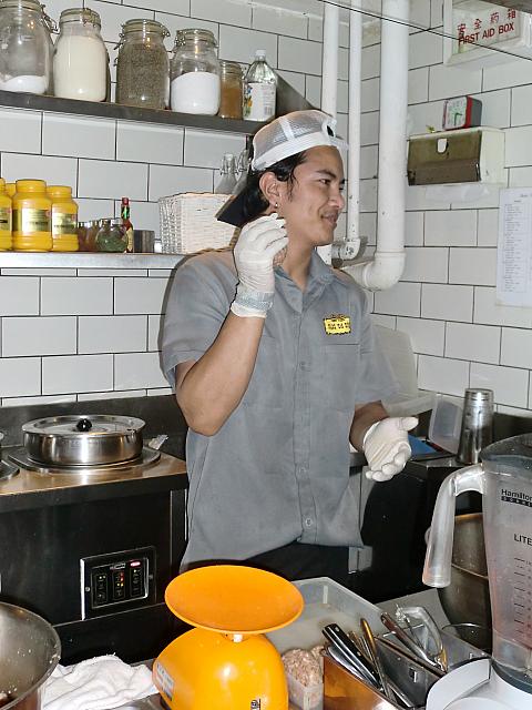 ひき肉をこねてハンバーガーを作っている店員さん