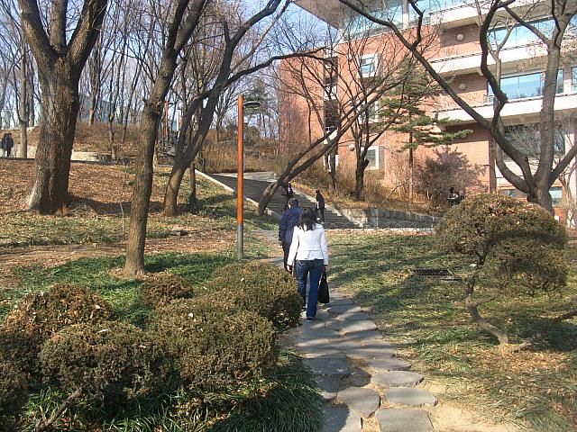 銅像向かって左脇を通り、⇒