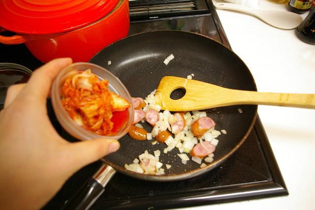 ９）キムチを加え色が軽く変わるまで炒める。