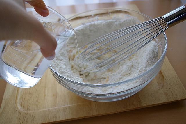 ⑤ 水を加え粘りが出るまでよく混ぜ合わせる。※粉と同量の水を入れる（季節によって水の分量が変わるので、少しづつ入れながら調整してください。）
