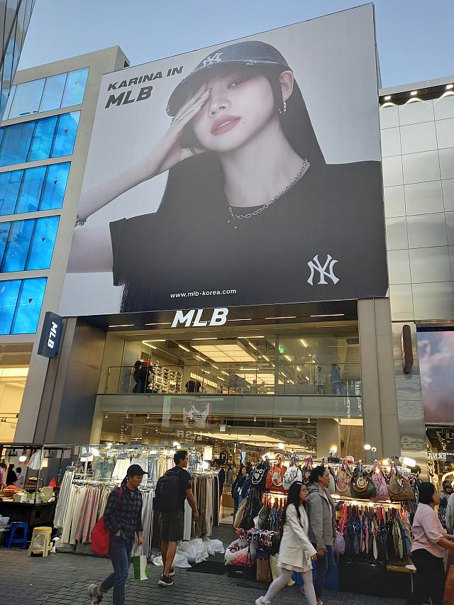 明洞メインストリートは人気のブランドがずらり~！<BR>MLBの新しいアンバサダーはaespaのカリナ。