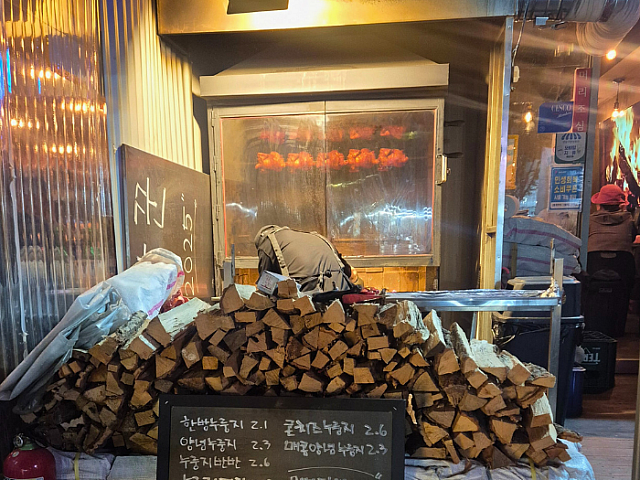 お店のすぐ外には、積まれたたきぎと焚火で焼かれるチキン達が。臨場感たっぷりです。