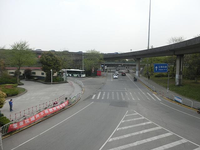 ①出たところは歩道橋上。降り口は左手ですが、下りたら上から見てこの方向（右手）へ進みます