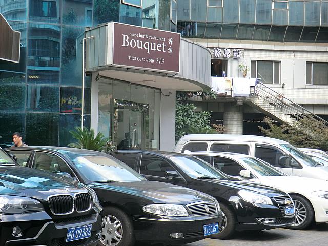 駐車場の奥に専用エレベーターのある入り口と看板があります