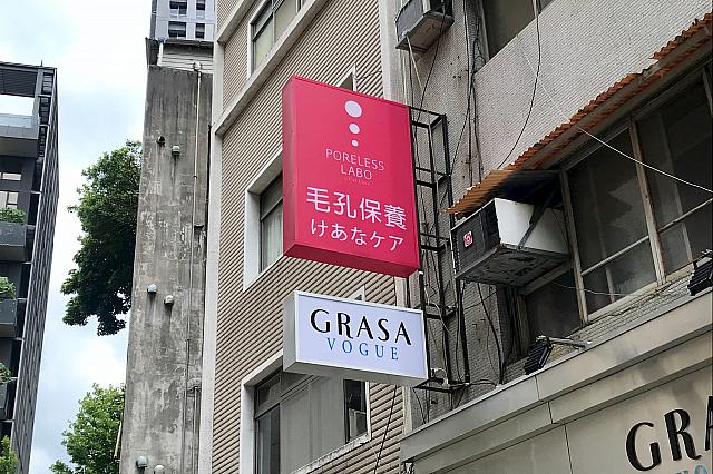 「GRASA VOGUE」の看板上の、鮮やかなピンクの「毛穴保養　けあなケア」が目印
