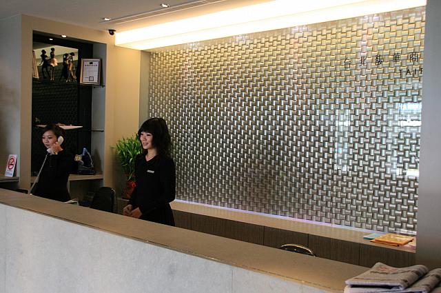 入口の自動ドアが開くと、正面にフロント。全体的に白いインテリアを取り入れているので、とても明るい印象を受けます。そして黒いスーツをパリッと着こなしたスタッフたちに迎えられます。