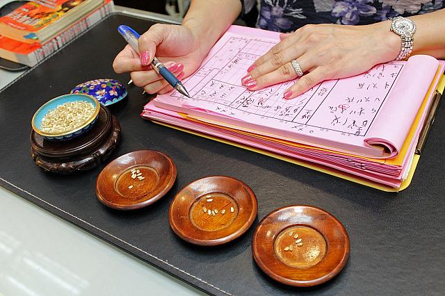 なにやら、ナビが選んだ米の種類と数を数え、紙に文字や数字を書いて計算しているよう。