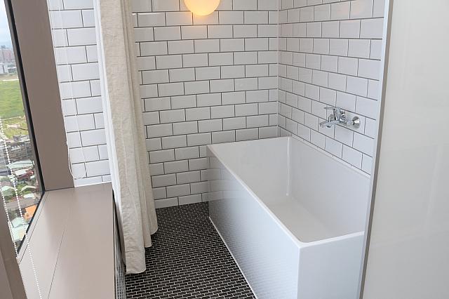 バスタブ。窓にはカーテンが付いています。ほかに、シャワールームとウォシュレット付きトイレが個室であります。