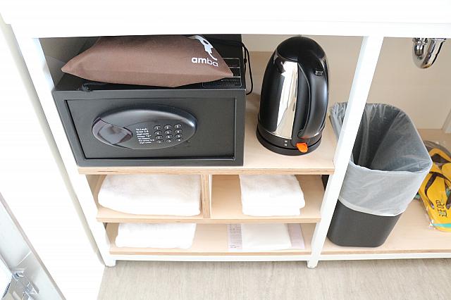 洗面台の下にハンドタオル、フェイスタオル、バスタオルや有料クリーニングサービスの袋が置いてあります。