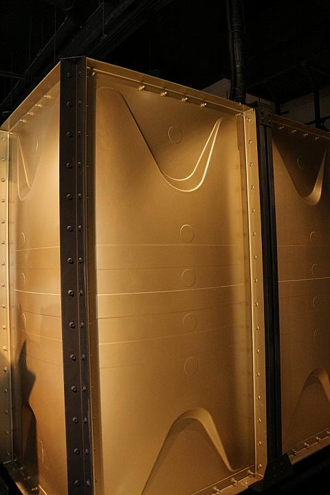 フロント右奥にある大きなゴールドの物体は貯水タンクです。通常は建物の上にありますが、建築物のバランスをとるため1Fに設置されています