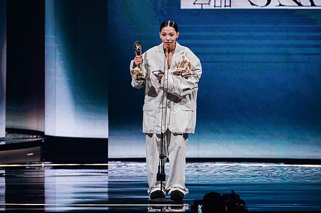 トロフィーと、ライブグッズの布バッグを握りしめる洪佩瑜