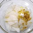 ３．イカはていねいに洗って水気を切り包丁をねかせて格子に切り込みを入れる。3cm角くらいの適当な大きさに切る。塩、胡椒、ごま油、ニンニクのみじん切り　 各少々をまぶして10分ほどおく。
