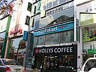 右側にHOLLY’S COFFEEのコーヒーショップが見えてきます。お店ははそのコーヒーショップのビルの2階です。