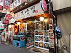 少し行くとすぐ右手にお店があります。白い看板には「釜山家」と日本語もあり。徒歩約４分。