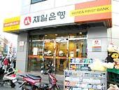 まっすぐ行くとオレンジ色の看板の第一銀行（Korea First Bank）があるのでそこを右に曲がります。