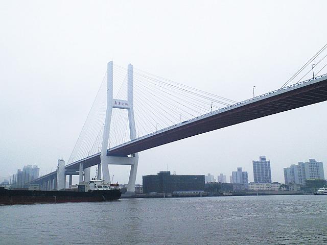「南浦大橋」の真下を通るローカルな渡し船。旧万博会場を遠くに望みながら黄浦江を渡ろう。