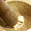2. パクチーの根、ニンニク、粒胡椒はクロック（臼）で叩く。
☆クロックがない場合はすり鉢で代用 
