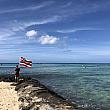 海に向かってハワイの州旗を持っている男性。